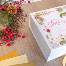 Load image into Gallery viewer, Christmas-themed gift box with decorative elements on a wooden surface
