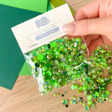 Load image into Gallery viewer, Green pearl gem mix with packaging labeled &#39;Pearl Gem Mix&#39; held by a hand on a wooden surface.
