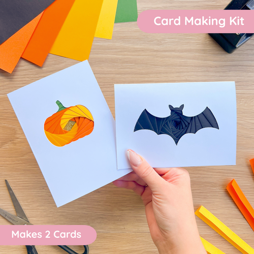 Card making kit with Halloween-themed cutouts on a wooden surface.