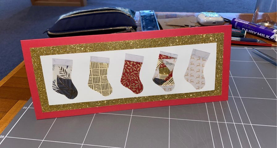 Christmas card with five stockings on - two of them are iris folded