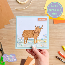 Load image into Gallery viewer, Brown Highland Cow Iris fold card with blue and white flower meadow embellishment

