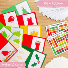 Load image into Gallery viewer, A flat lay of Christmas greeting cards and printed greeting sheets on a light wood surface. The set includes red, green, yellow, and white cards with holiday illustrations such as a Santa hat, bell, Christmas tree, stocking, bird, holly, and ornaments.

