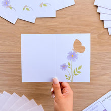 Load image into Gallery viewer, A hand holding a mini butterfly card aperture with printed lilac flowers
