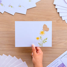 Load image into Gallery viewer, A hand holding a mini butterfly card aperture with printed yellow flowers
