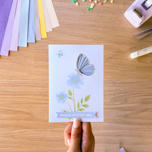 Load image into Gallery viewer, A blue iris fold butterfly greeting card with printed blue flowers, a resin blue butterfly and  'Have a wonderful day' text.
