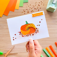 Load image into Gallery viewer, A hand holds a white greeting card featuring an iris fold pumpkin design in shades of orange, yellow, and green, with autumn leaves. The card has an orange banner that reads 'Best wishes'.
