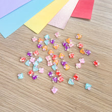 Load image into Gallery viewer, Mini toadstool embellishments on a wooden table with colourful paper
