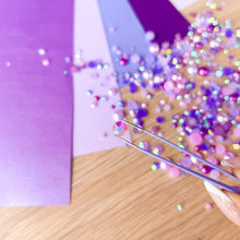 Load image into Gallery viewer, Hand using tweezers to pick up gems on a purple surface
