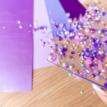 Load image into Gallery viewer, Hand using tweezers to pick up gems on a wooden surface
