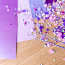 Load image into Gallery viewer, Colorful gems scattered on a wooden surface with a purple background
