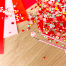Load image into Gallery viewer, close up of tweezers holding a pink pearl
