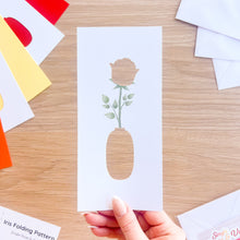 Load image into Gallery viewer, Hand holding an aperture card with a rose design on a wooden table
