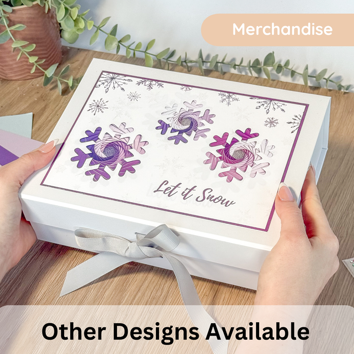 Gift box with silver ribbon and purple snowflake design with 'Let it snow' greeting