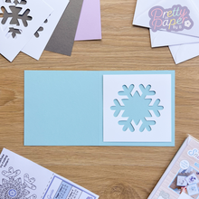 Load image into Gallery viewer, Snowflake Aperture in white against blue card
