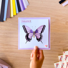 Load image into Gallery viewer, Purple iris fold swallowtail butterfly greeting card with 'thinking of you' text and three lilac resin flowers in one corner
