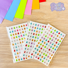 Load image into Gallery viewer, Colorful gem stickers on a wooden surface with &#39;Pretty in Paper by B&#39; branding.
