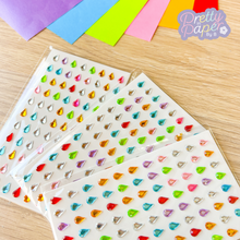 Load image into Gallery viewer, Colorful teardrop-shaped stickers on a wooden surface with &#39;Pretty in Paper&#39; branding.
