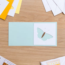 Load image into Gallery viewer, Butterfly aperture cut-out on pale turquoise card blank
