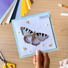 Load image into Gallery viewer, An example of an iris fold butterfly greeting card made with the aperture and card blank and embellished with resin flowers and leaves and 'Thinking of you' text
