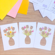 Load image into Gallery viewer, Three paper cutouts of floral designs on a wooden surface with colorful paper and envelopes.
