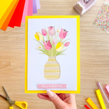 Load image into Gallery viewer, Hand holding a card with a floral design and 'Have a lovely birthday' text on a wooden surface.
