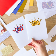 Load image into Gallery viewer, Two crown iris folding cards. One in gold and one in red, white and blue.
